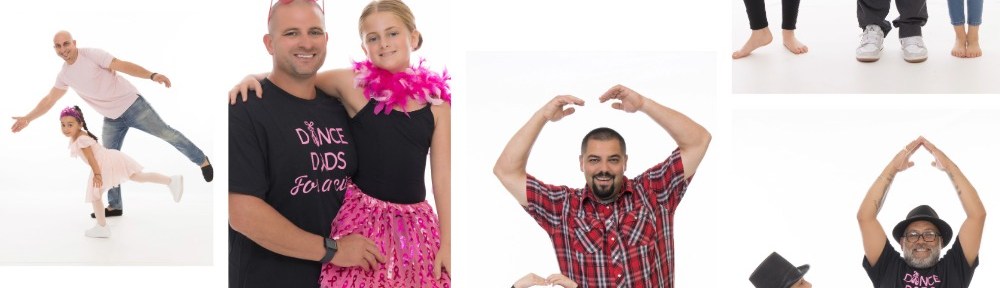 Stacks of bright pink t-shirts laid out on a textured surface, each shirt featuring messages like 'I Wear Pink for My Mom' and 'I Wear Pink for My Sister' with breast cancer awareness ribbons. The shirts are part of the Dance Dads for a Cure fundraiser.