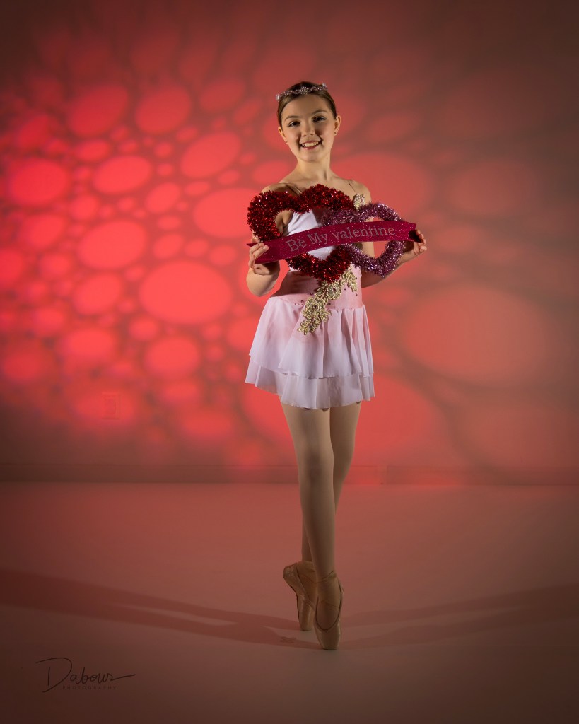 ballet dancer on point holding a be my valentines heart