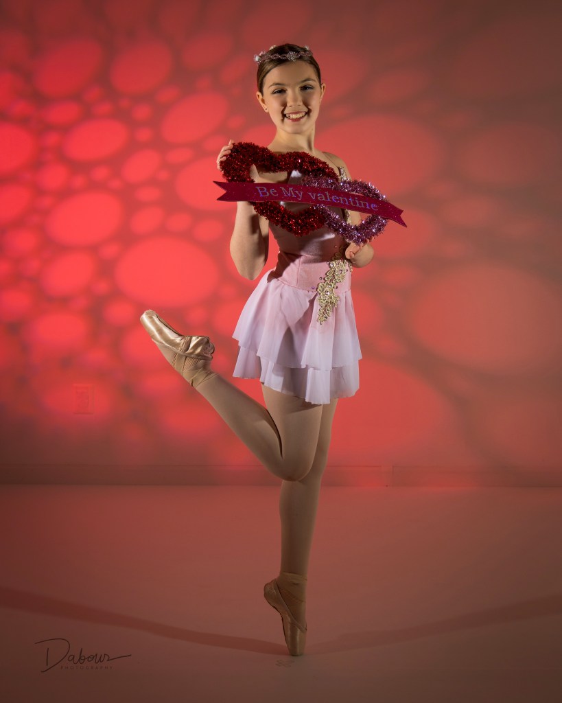 dancer on pointe holding a be my valentine heart