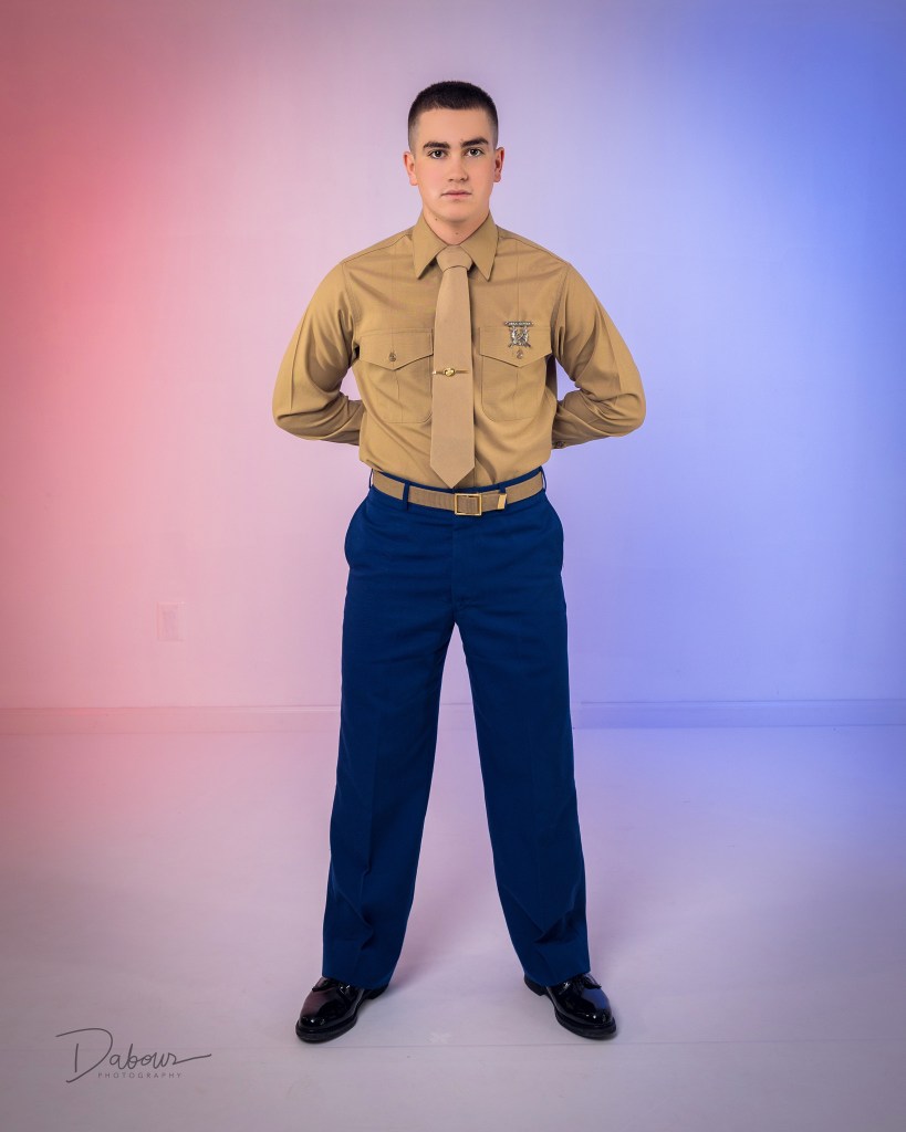 A side-by-side comparison of a U.S. Marine posing in two different uniforms: the Service Charlie tan shirt and blue trousers on the left, and the formal Dress Blue uniform with white cover on the right.