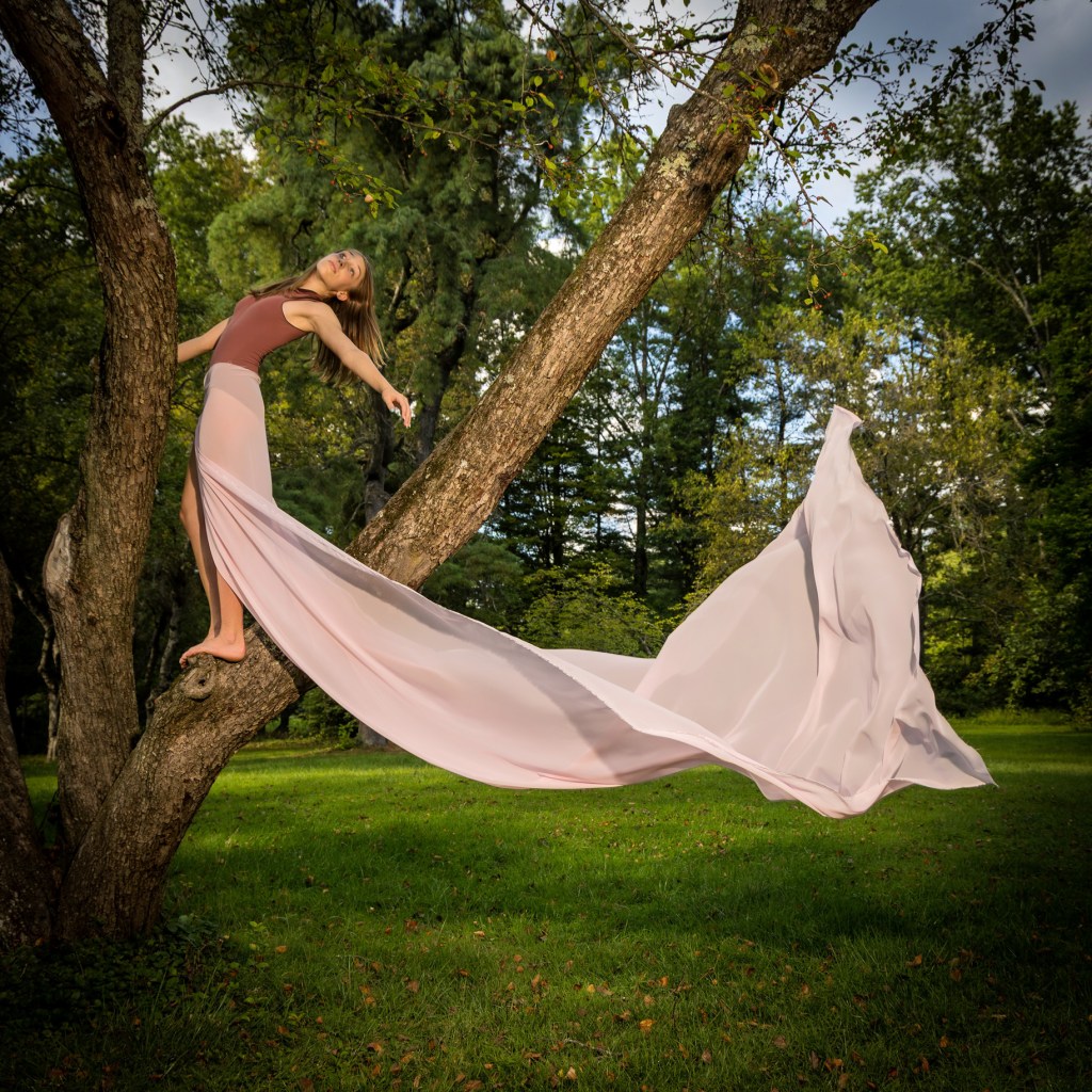 Dance Ambassador Ellery posing in a white dress in a wooded park setting, New Jersey dance photography