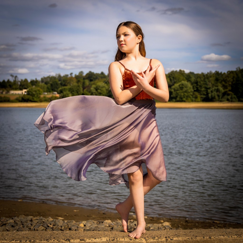 Ballerina Vivi Taggart performing a graceful pose outdoors near a body of water