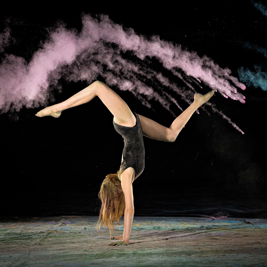 Action shot of dancer Ellery with pink powder effect during a dance portrait session.