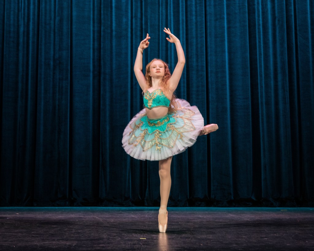 Dabour Photography dance ambassadors, including Lily, posing together in the ornate lobby of the State Theatre of the Arts. The dancers are in various ballet poses against the gold-leaf and velvet decor.