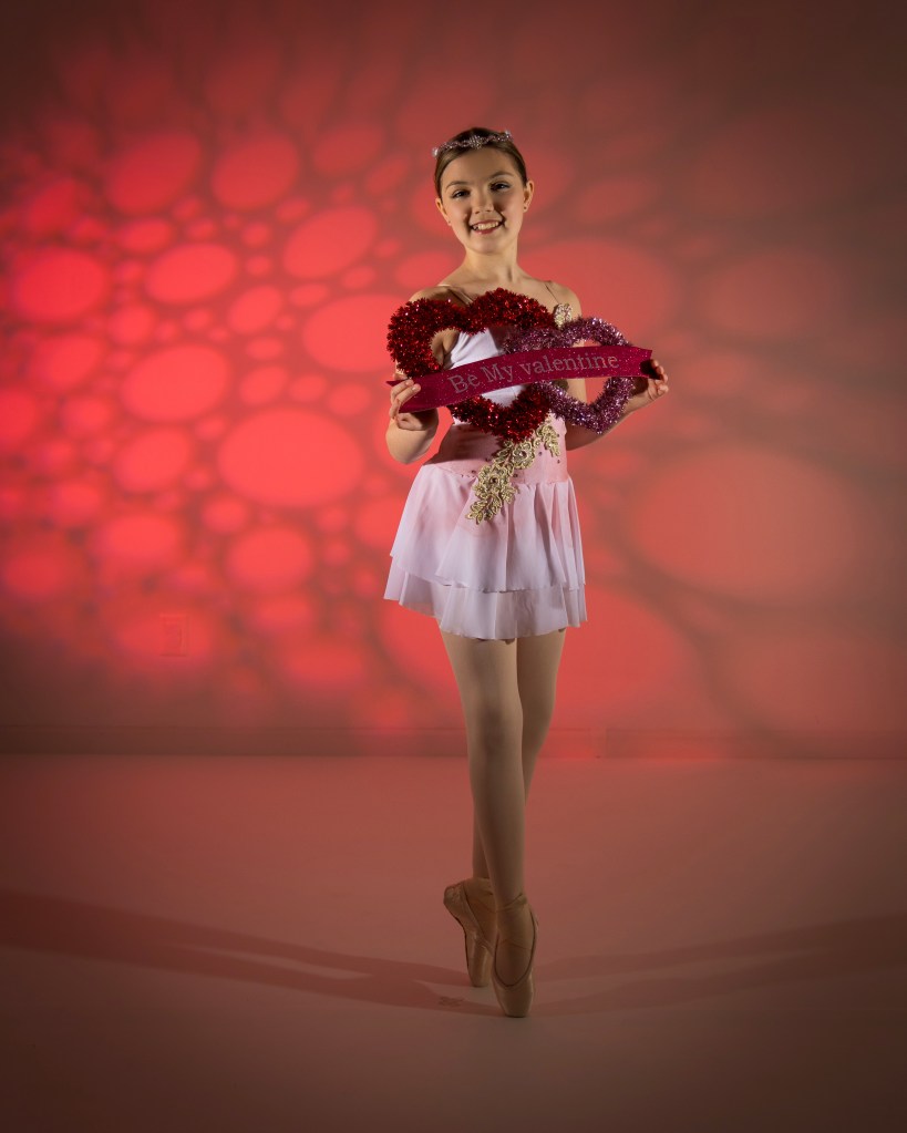 Ballerina Vivi Taggart performing a graceful pose with a valentine theme