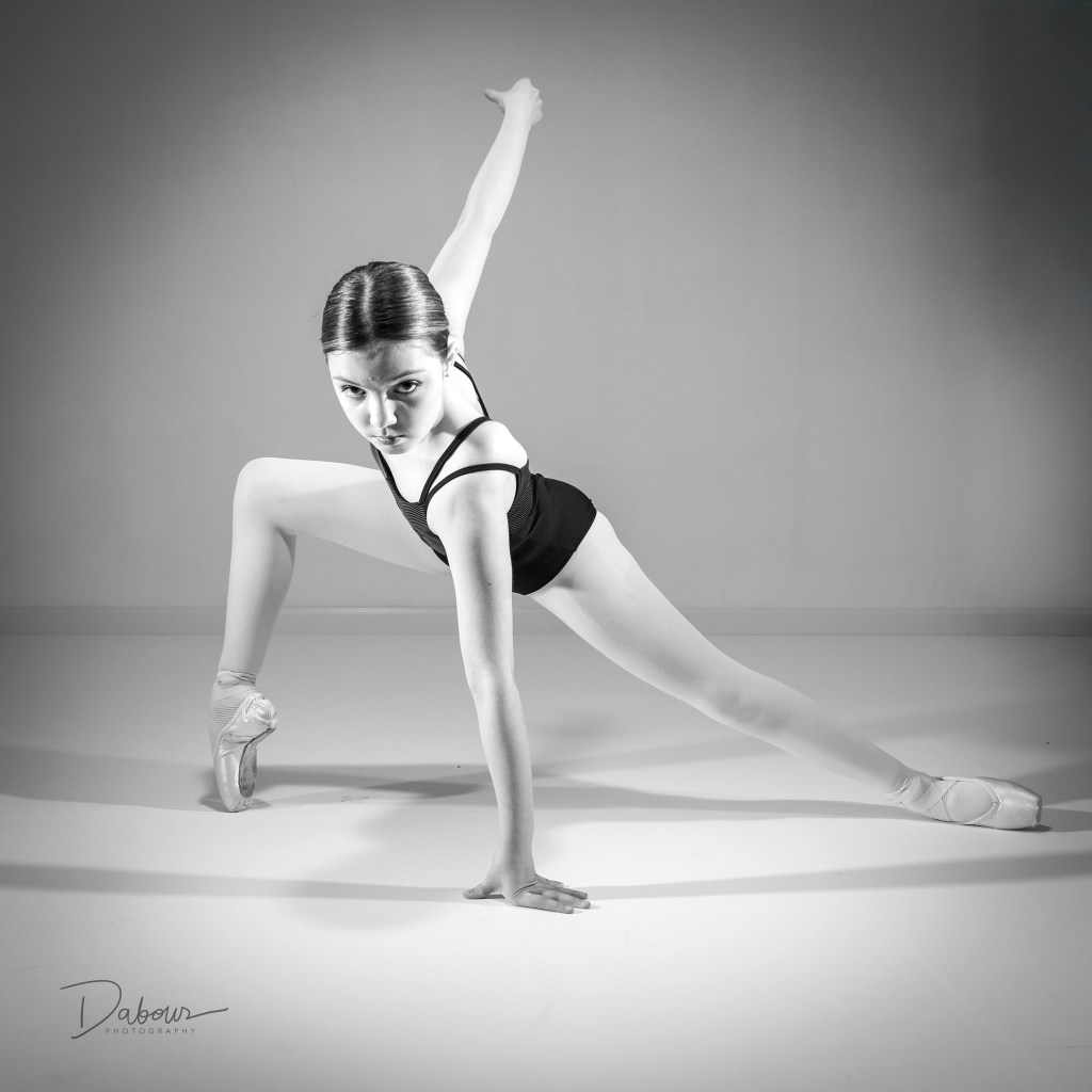 Dancer Vivi Taggart performing a graceful pose in a studio in black and white